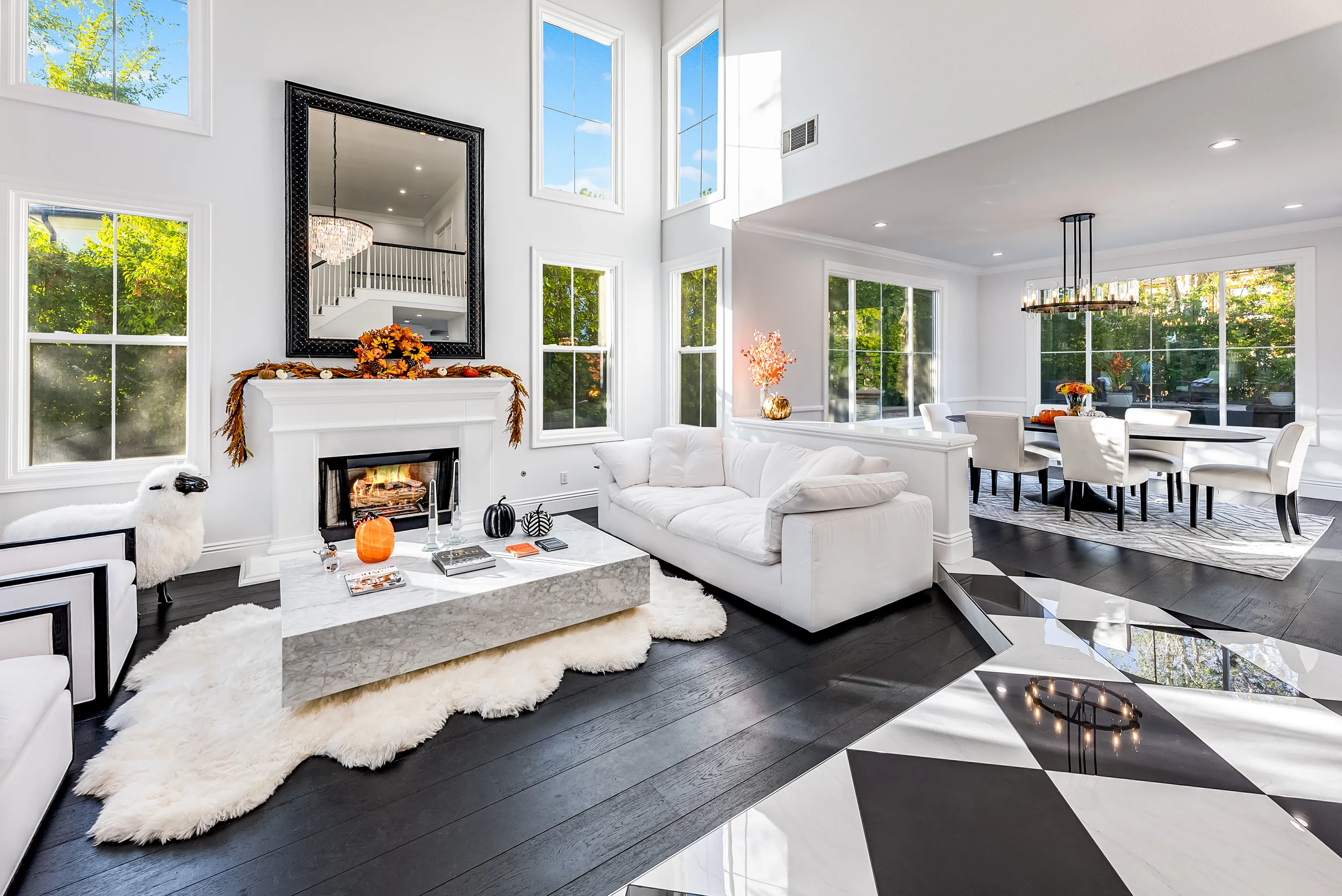 Two-story great room with white fireplace and black-and-white marble floor