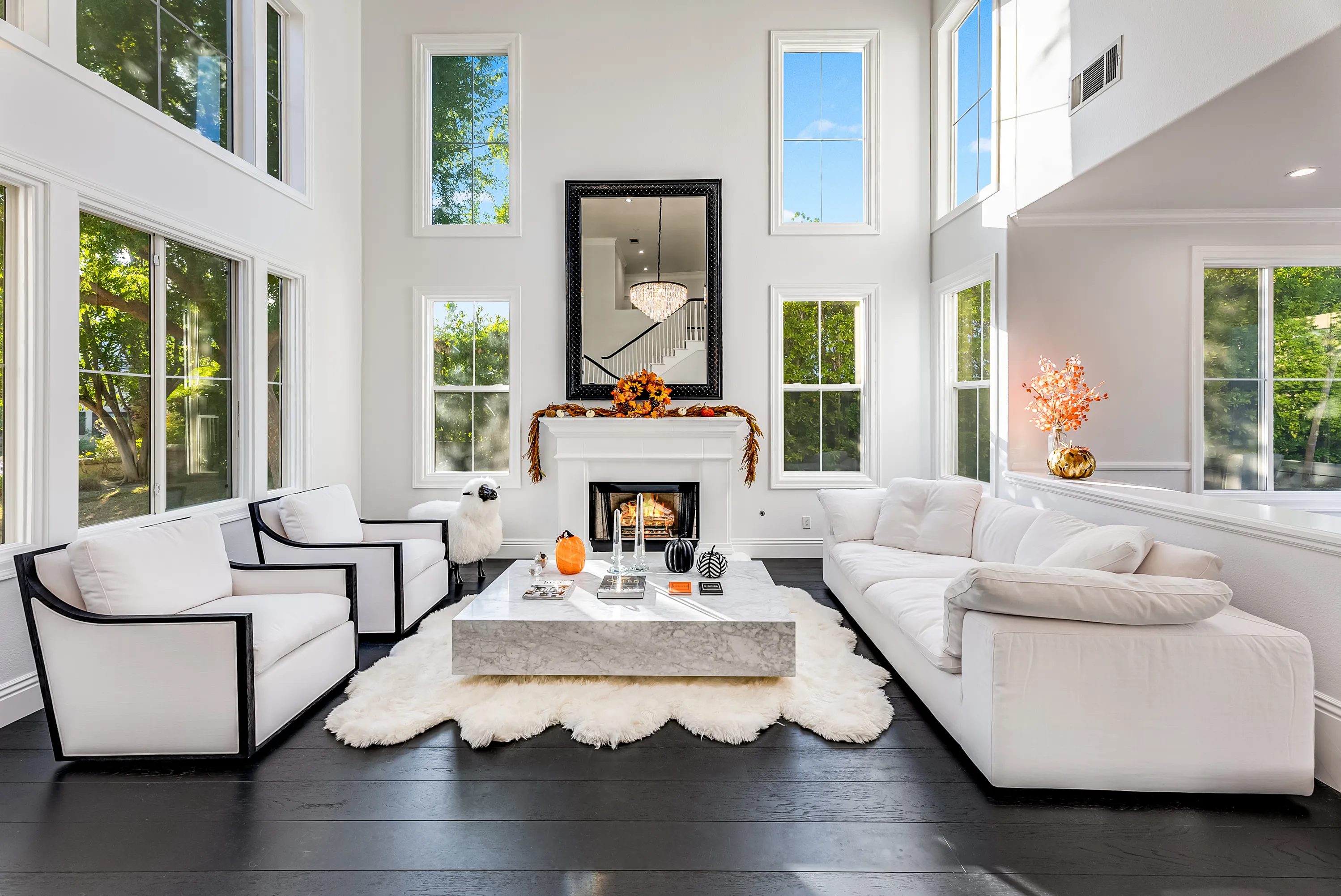 Great room seating area with fireplace and tall windows