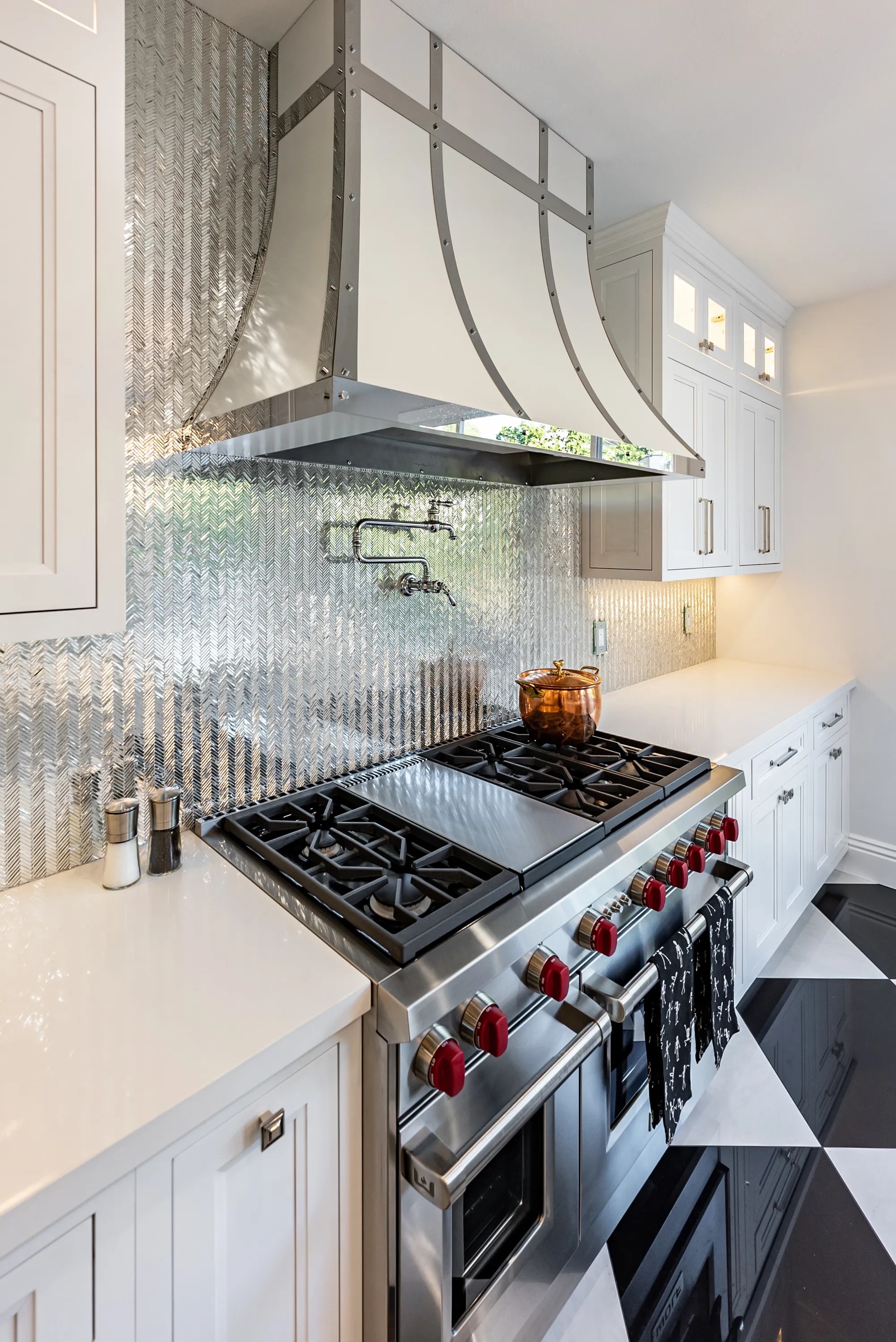 Custom range hood and mirrored glass backsplash