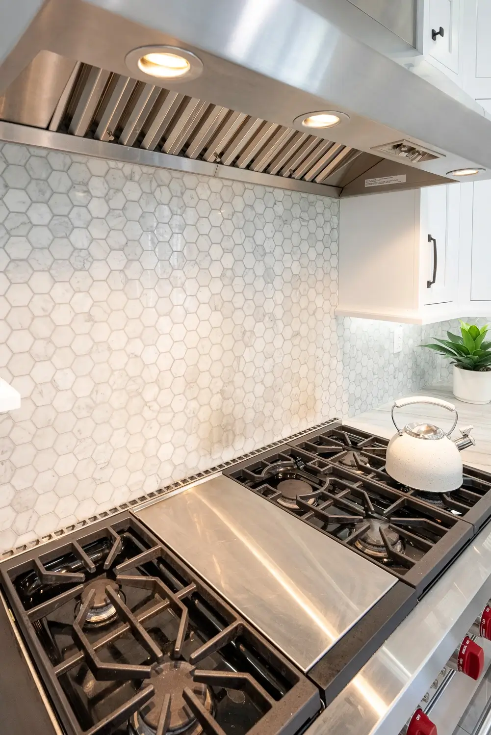 Close-up of gas cooktop and stainless hood