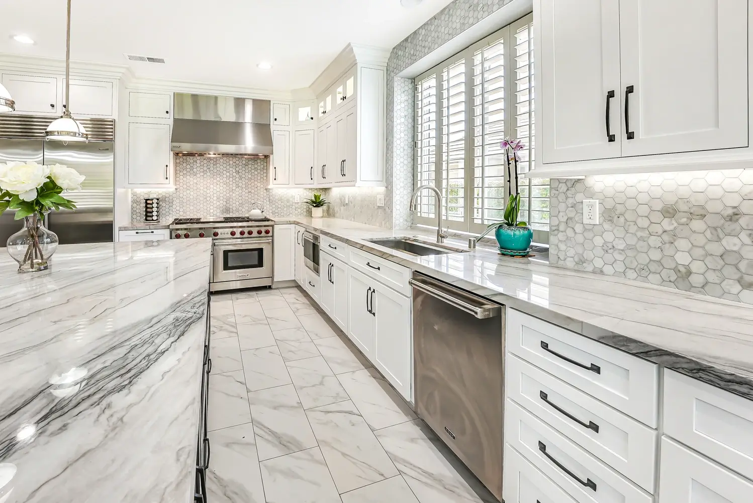 White kitchen with marble hex backsplash and plantation shutters in Dos Vientos