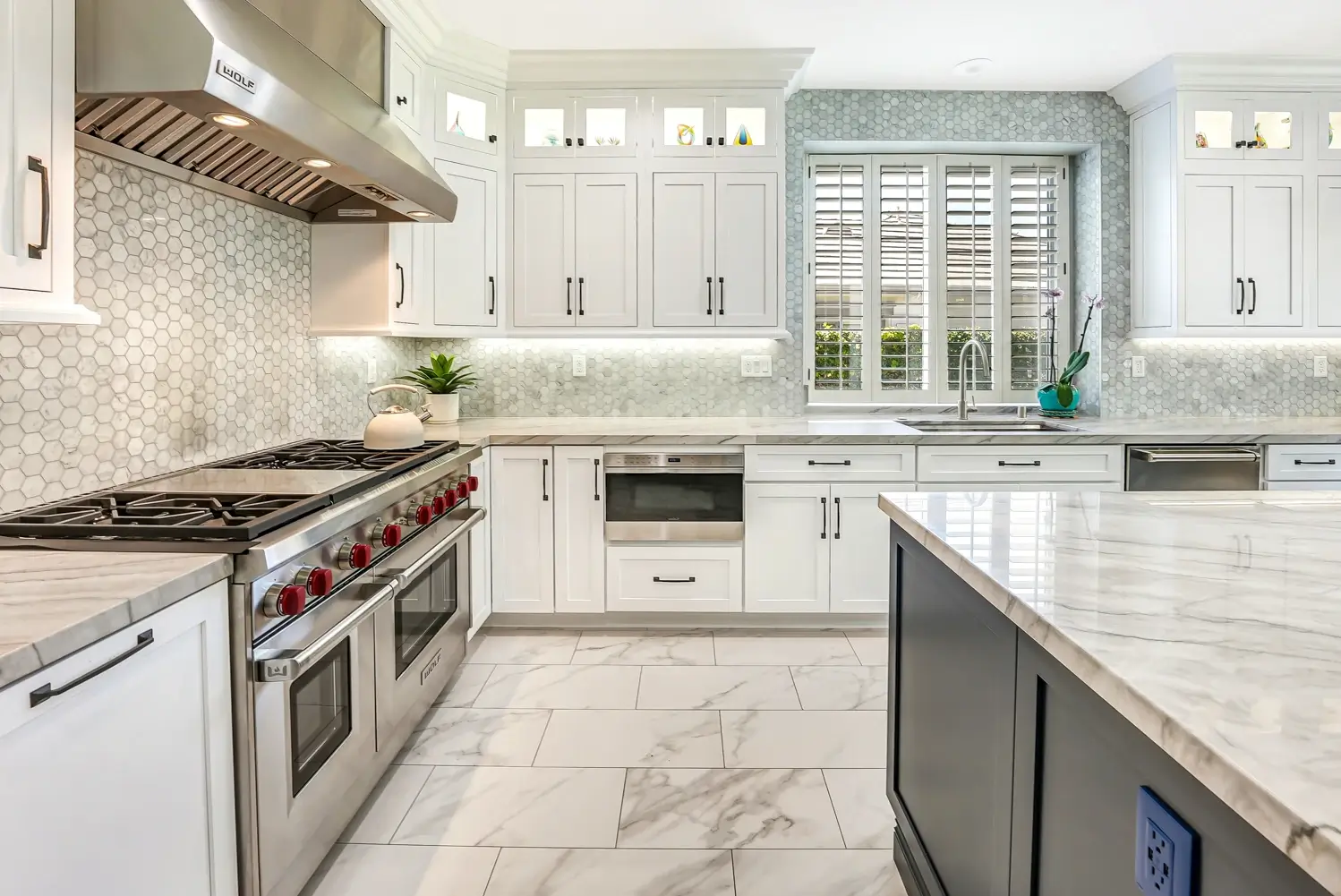 Range wall with glass-front upper cabinets and under-cabinet lighting