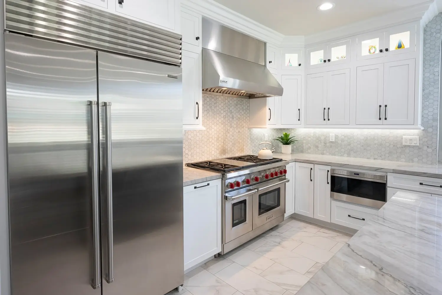 Built-in refrigerator and pantry cabinets with marble-look floors