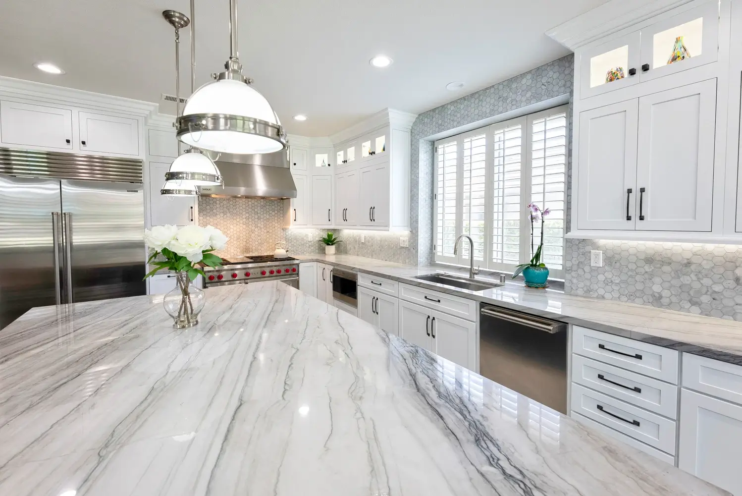 Kitchen sink under shuttered window with island in the foreground