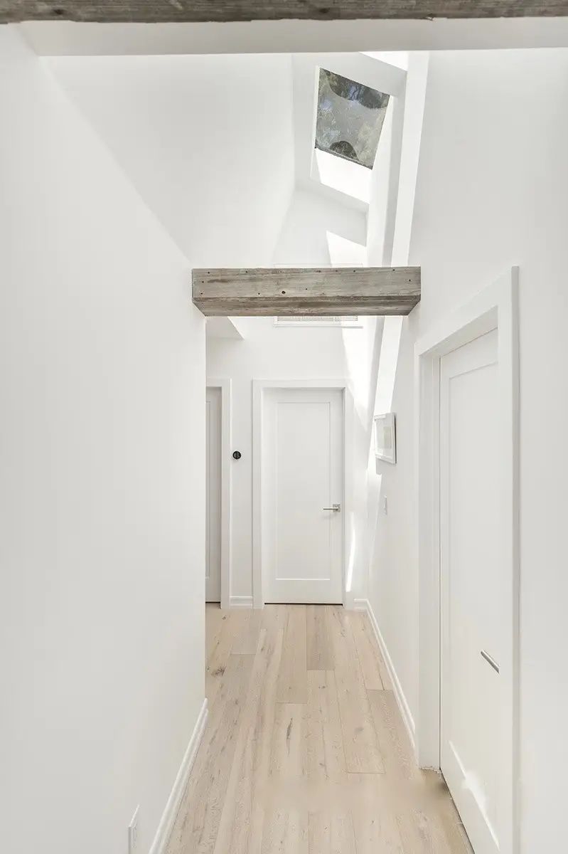 Hallway with skylight, oak floors and reclaimed beam header