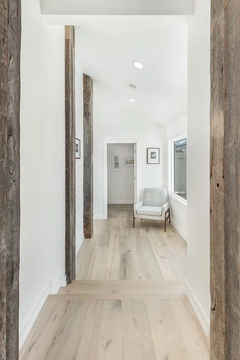 Hallway with reclaimed-wood posts leading to a sitting area