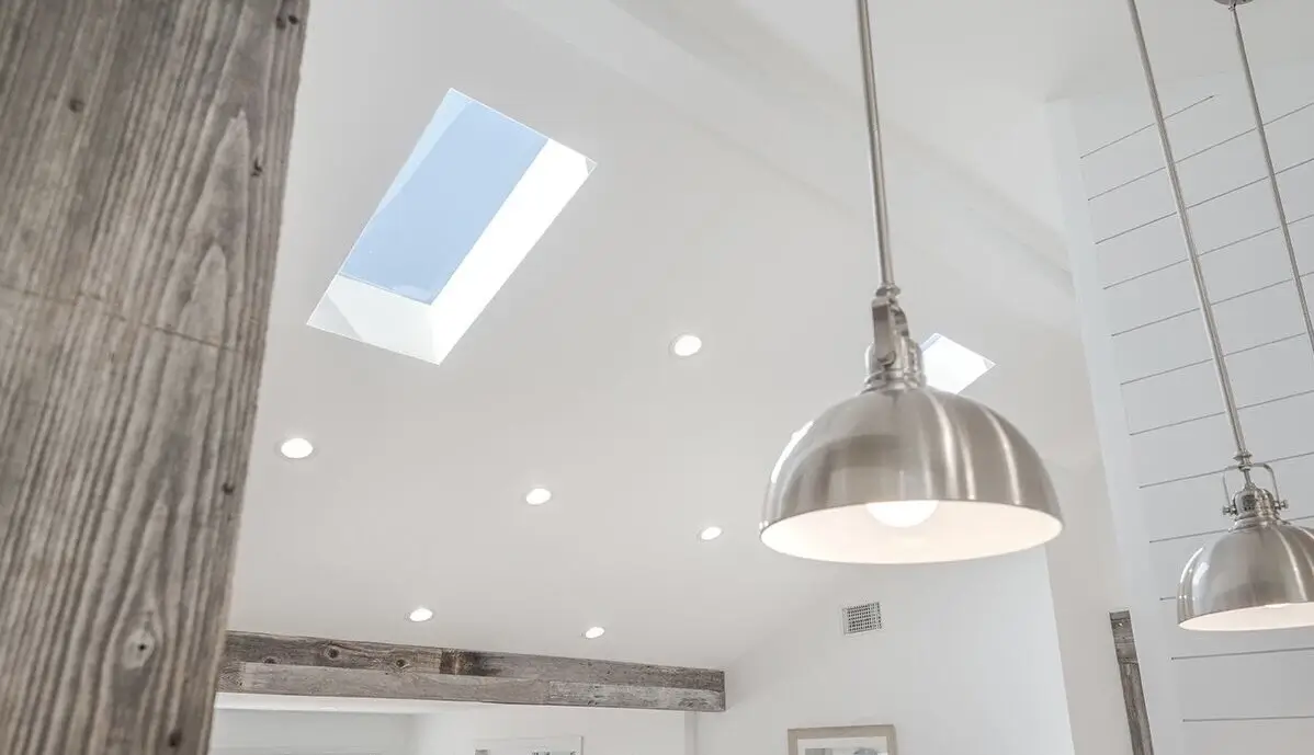 Vaulted ceiling with skylight, reclaimed beams and industrial pendant lights