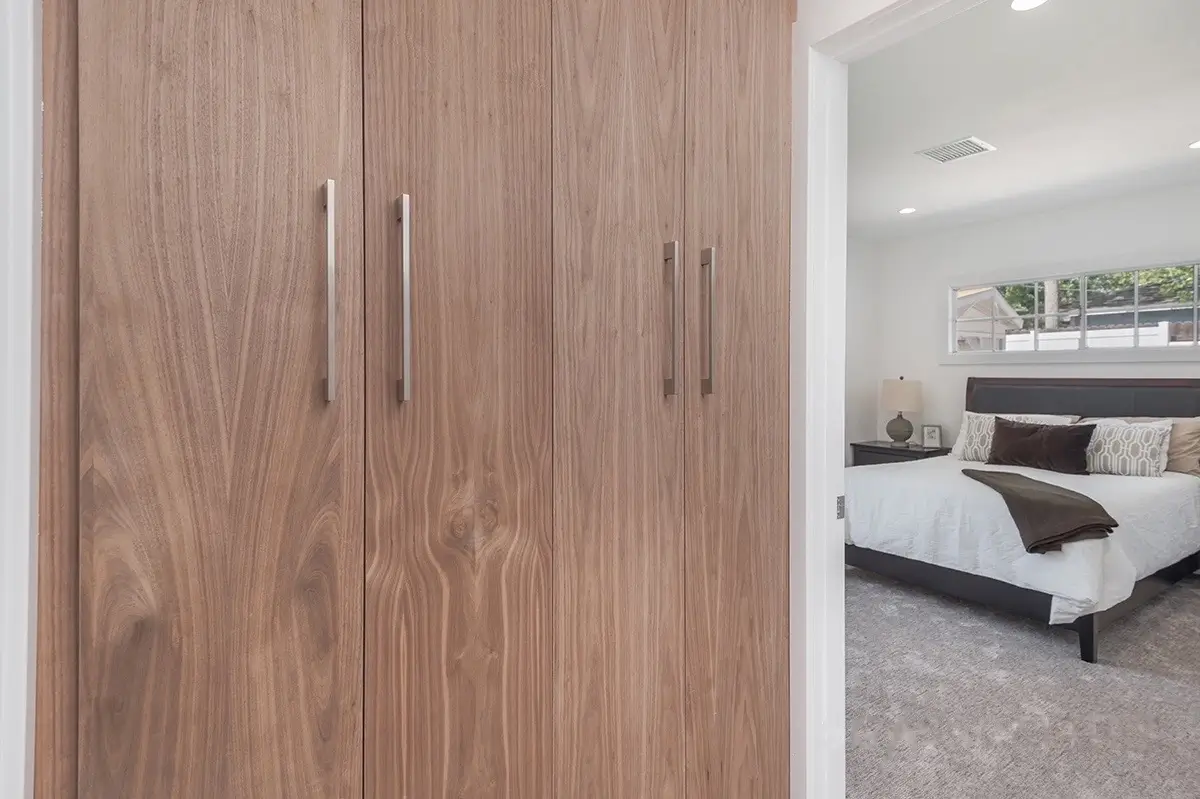 Walnut closet doors with vertical pulls in the primary bedroom