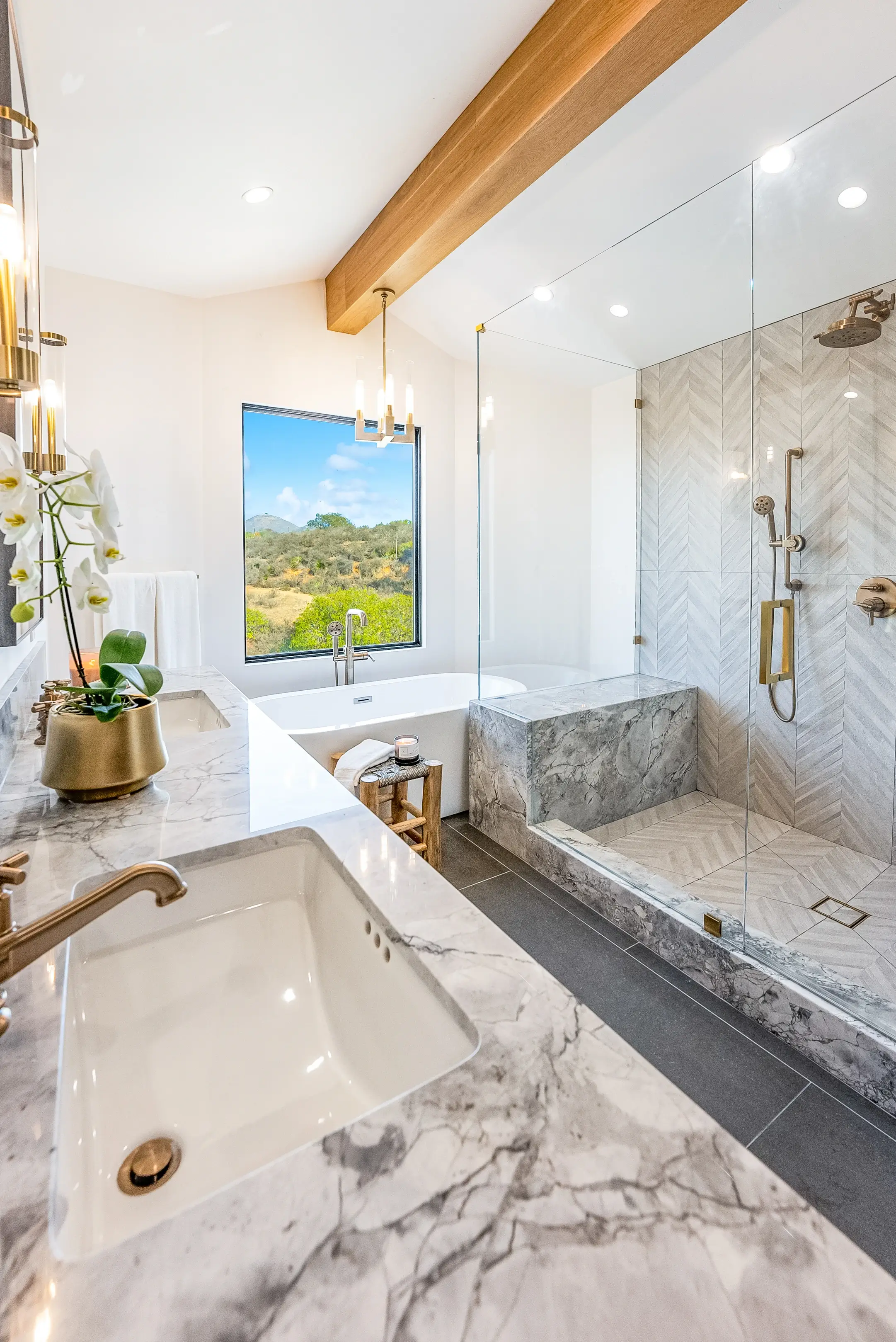 Freestanding tub with marble surround under a hillside window