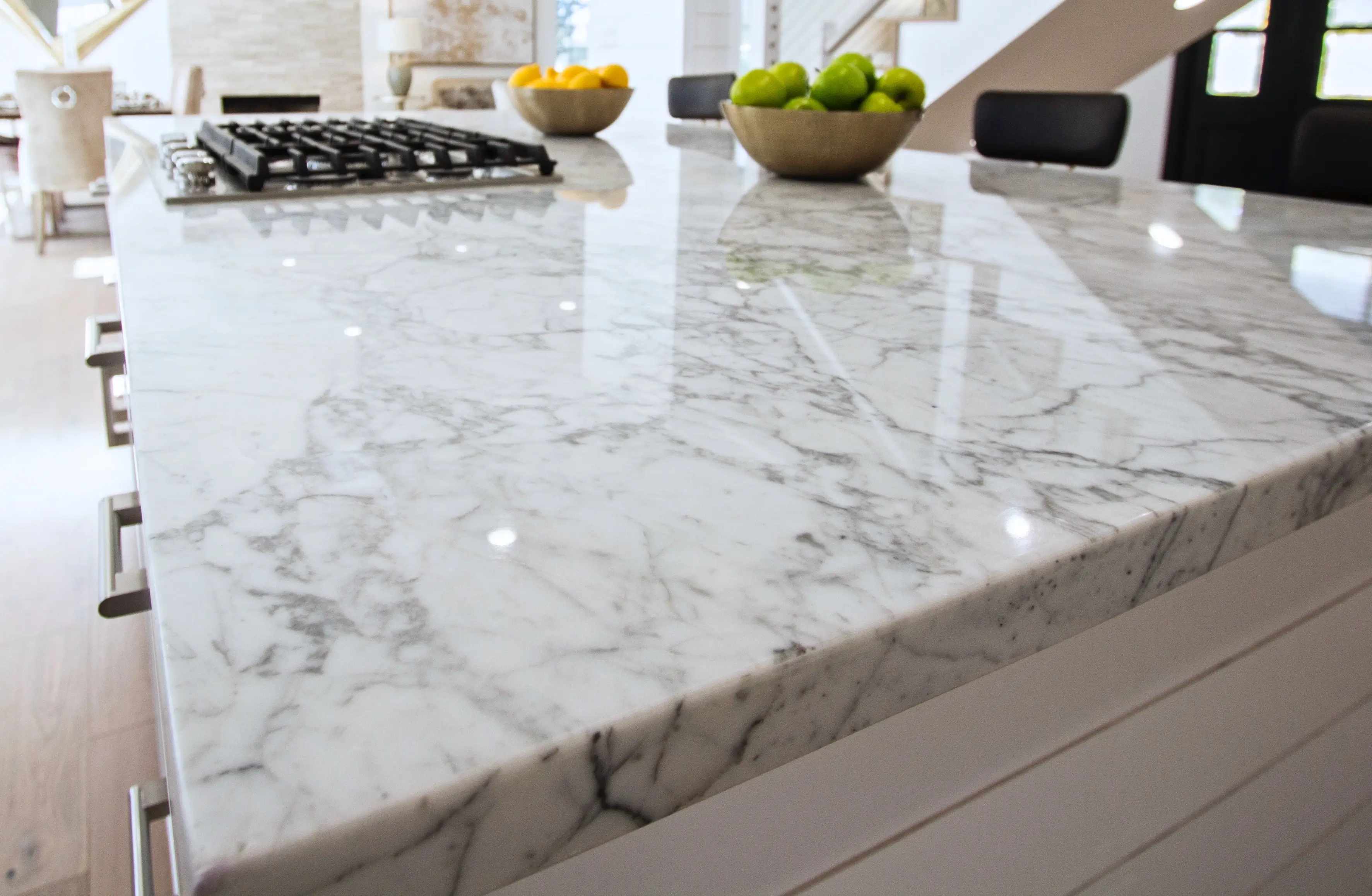 Marble island with gas cooktop and brass hardware