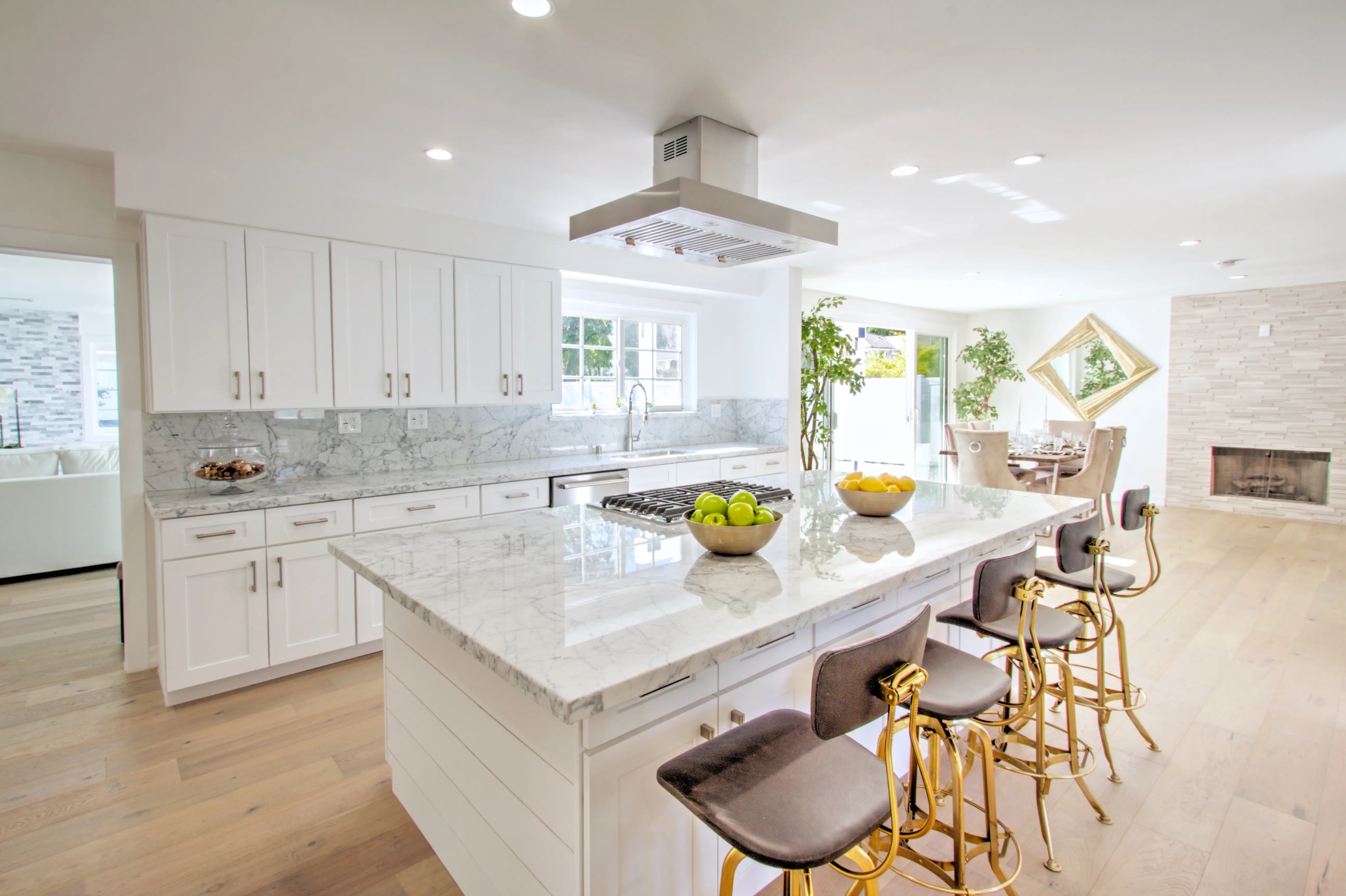 Full kitchen view with island, hood and marble backsplash