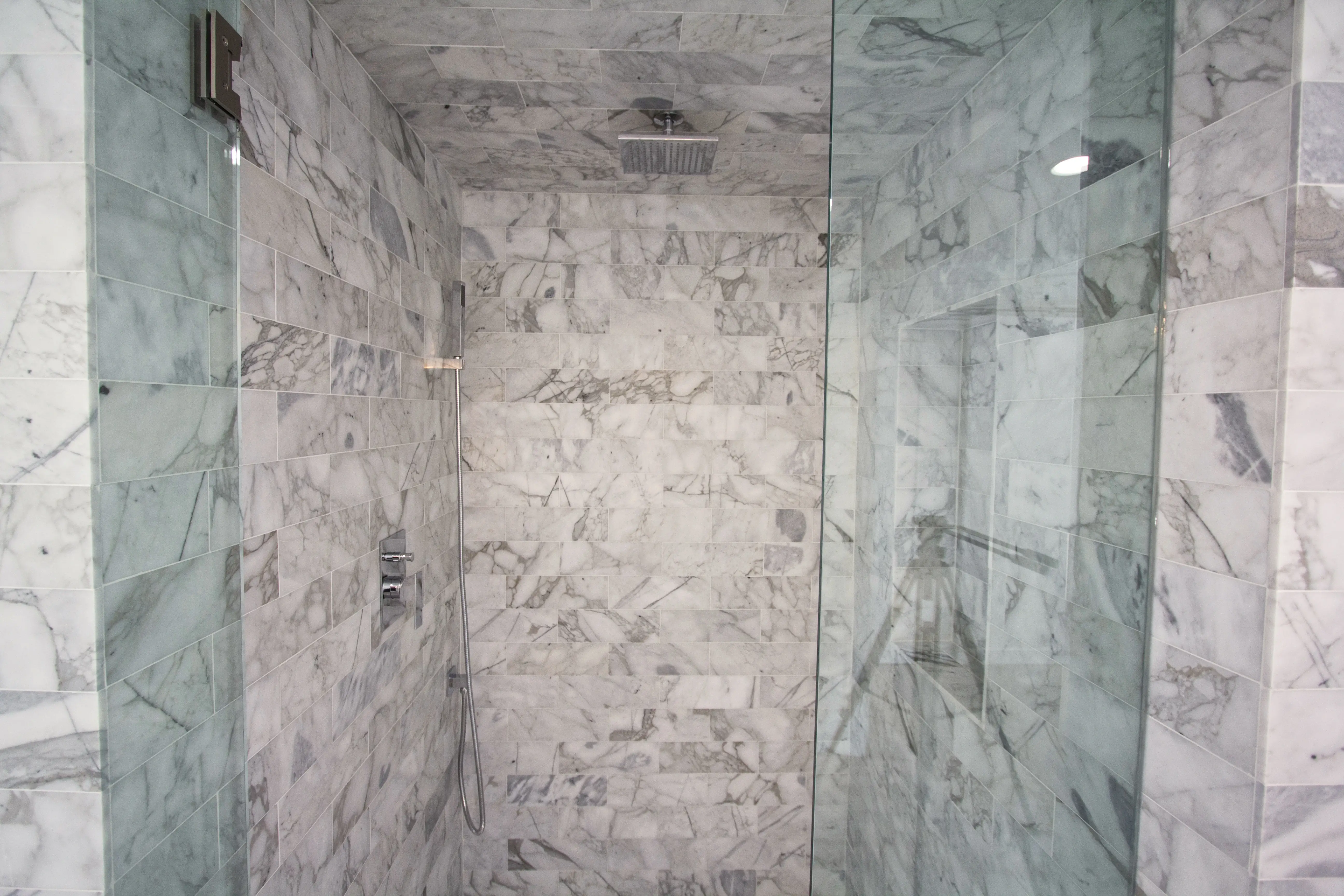 Floor-to-ceiling marble shower with rain head