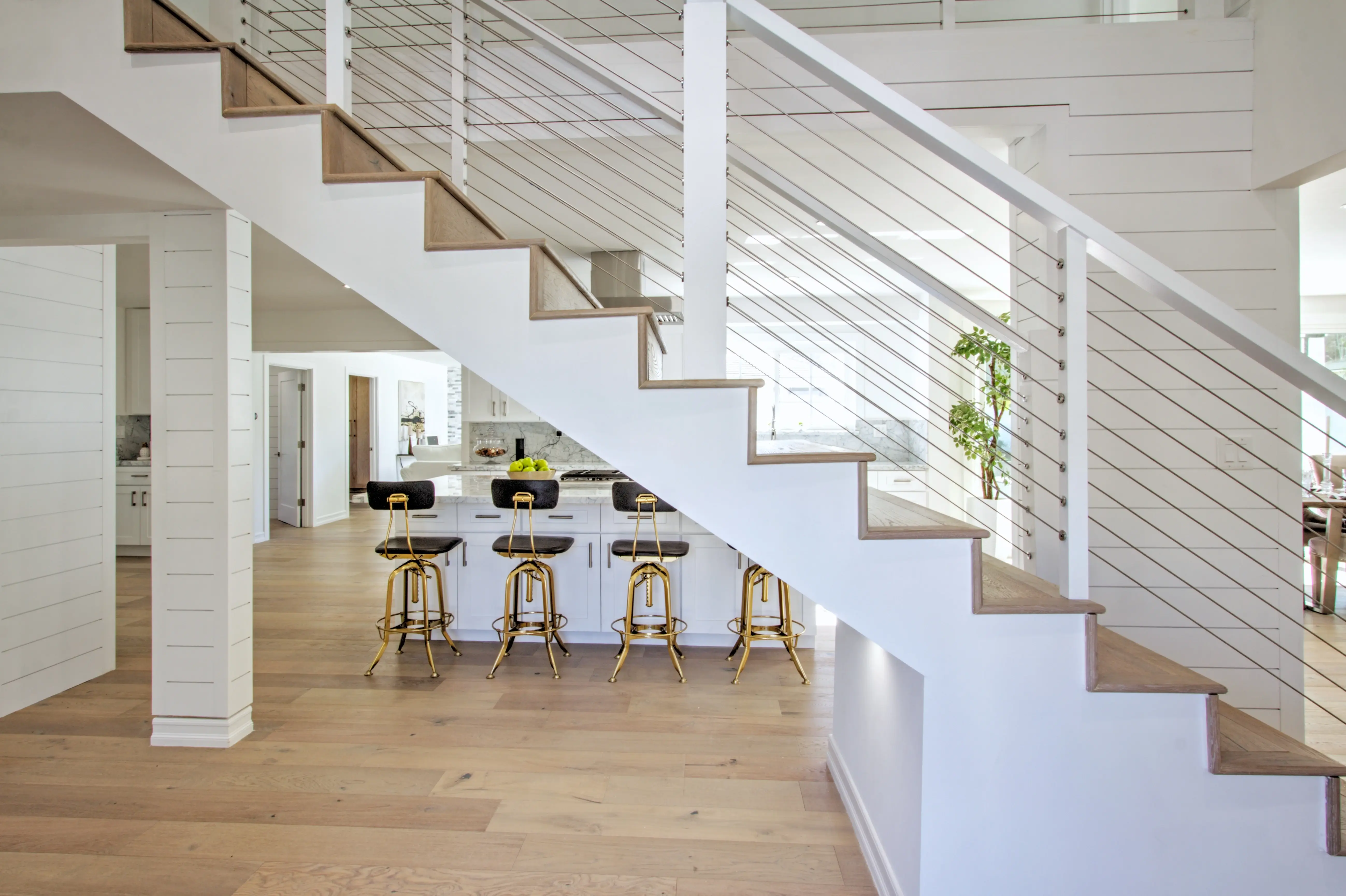 Open staircase with cable railing looking into the kitchen in North Ranch