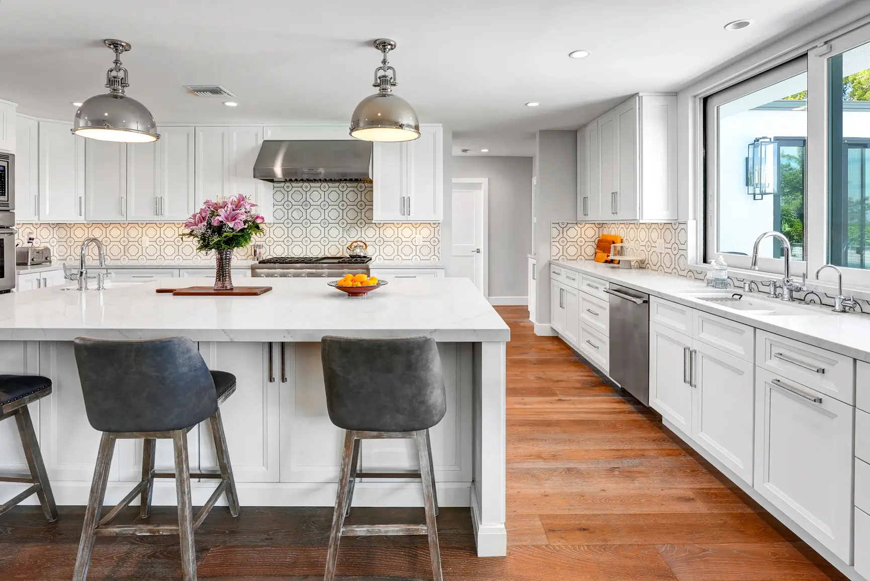 White kitchen island with gray stools and dome pendants in Studio City