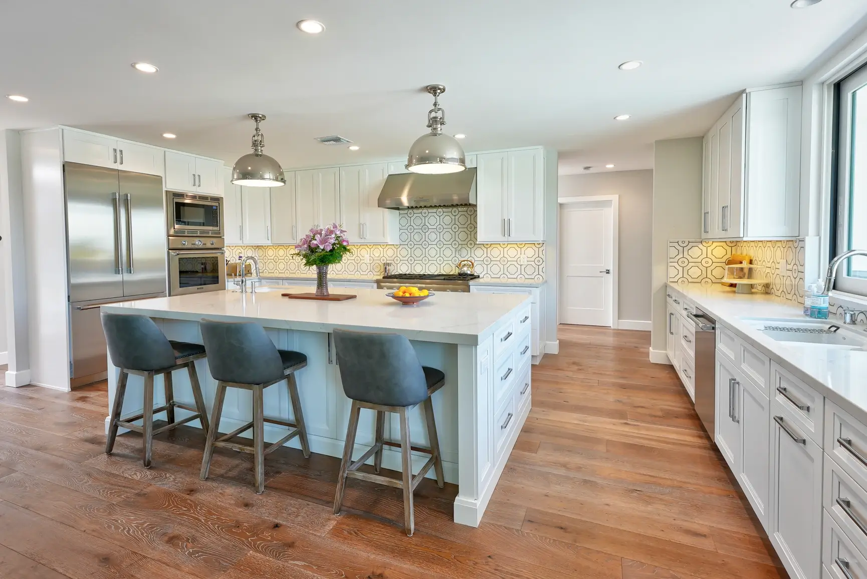 Kitchen with patterned tile backsplash, built-in refrigerator and hardwood floors