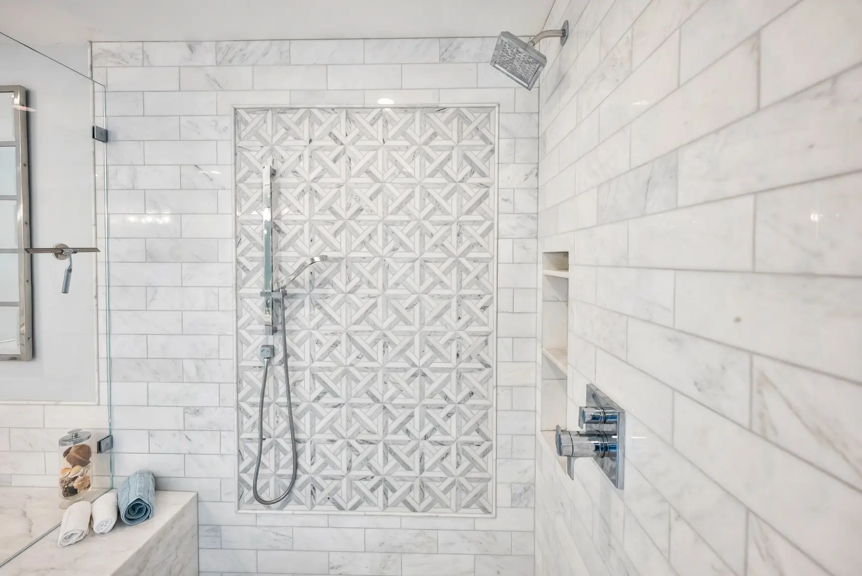 Shower with marble mosaic accent wall and tiled niche