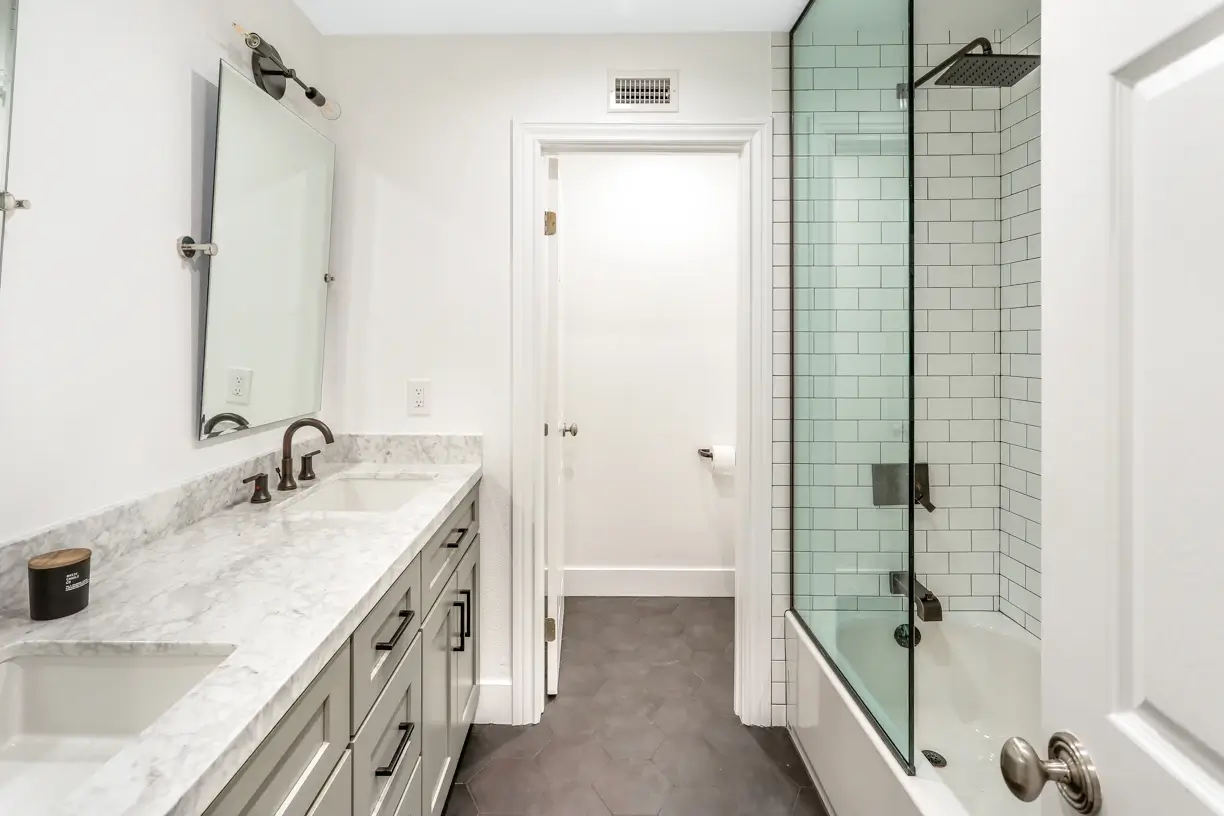 Guest bathroom with marble vanity and white subway-tile tub shower