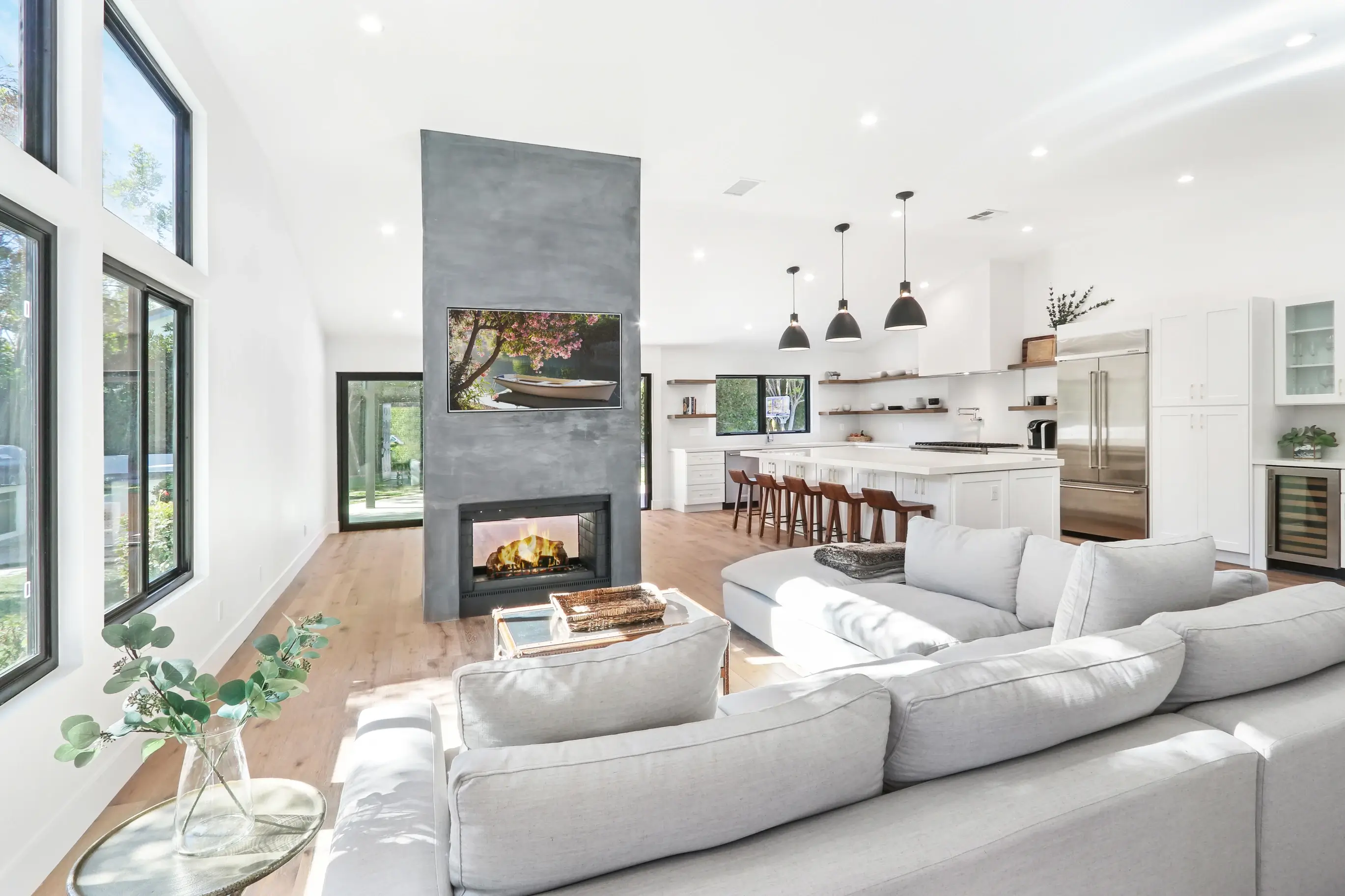 Two-sided concrete fireplace between living room and kitchen